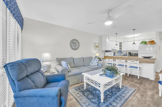 a living room with furniture kitchen view and a window