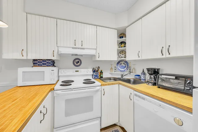 a view of a kitchen with a sink stove and cabinets