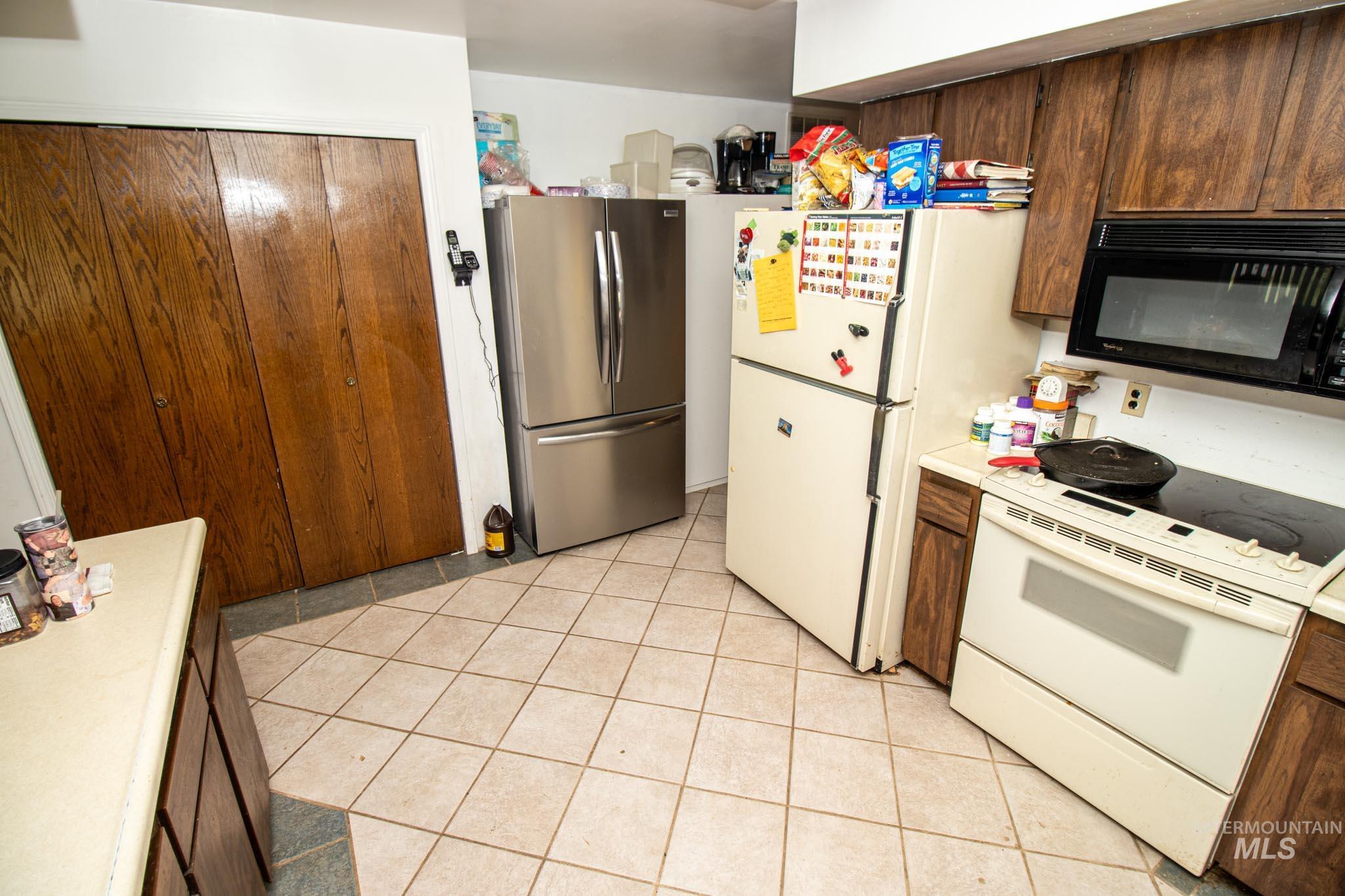 105 Weippe Avenue Weippe, ID 83553 - Photo 20 of 43 Kitchen featuring white appliances, light countertops, and light tile patterned flooring