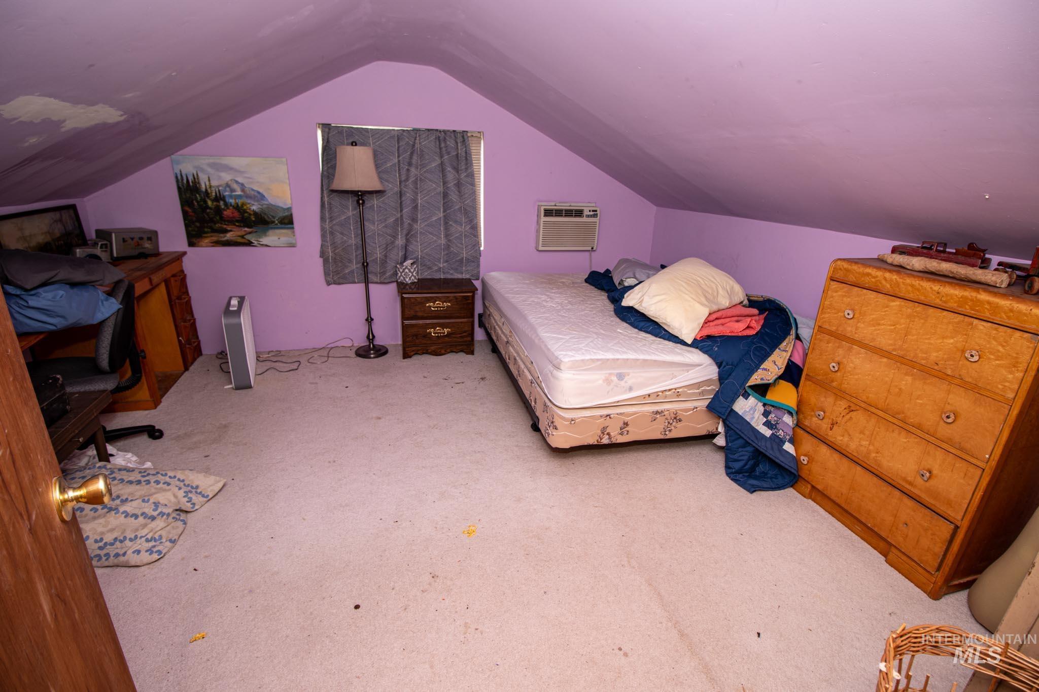 105 Weippe Avenue Weippe, ID 83553 - Photo 34 of 43 Bedroom featuring carpet floors, vaulted ceiling, and a wall mounted air conditioner