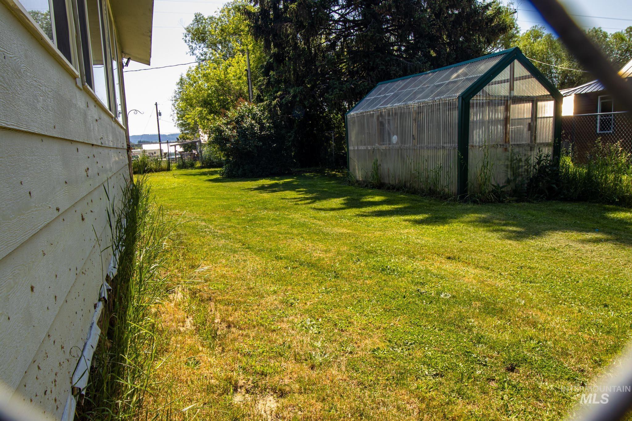 105 Weippe Avenue Weippe, ID 83553 - Photo 7 of 43 View of yard featuring a greenhouse and an outbuilding