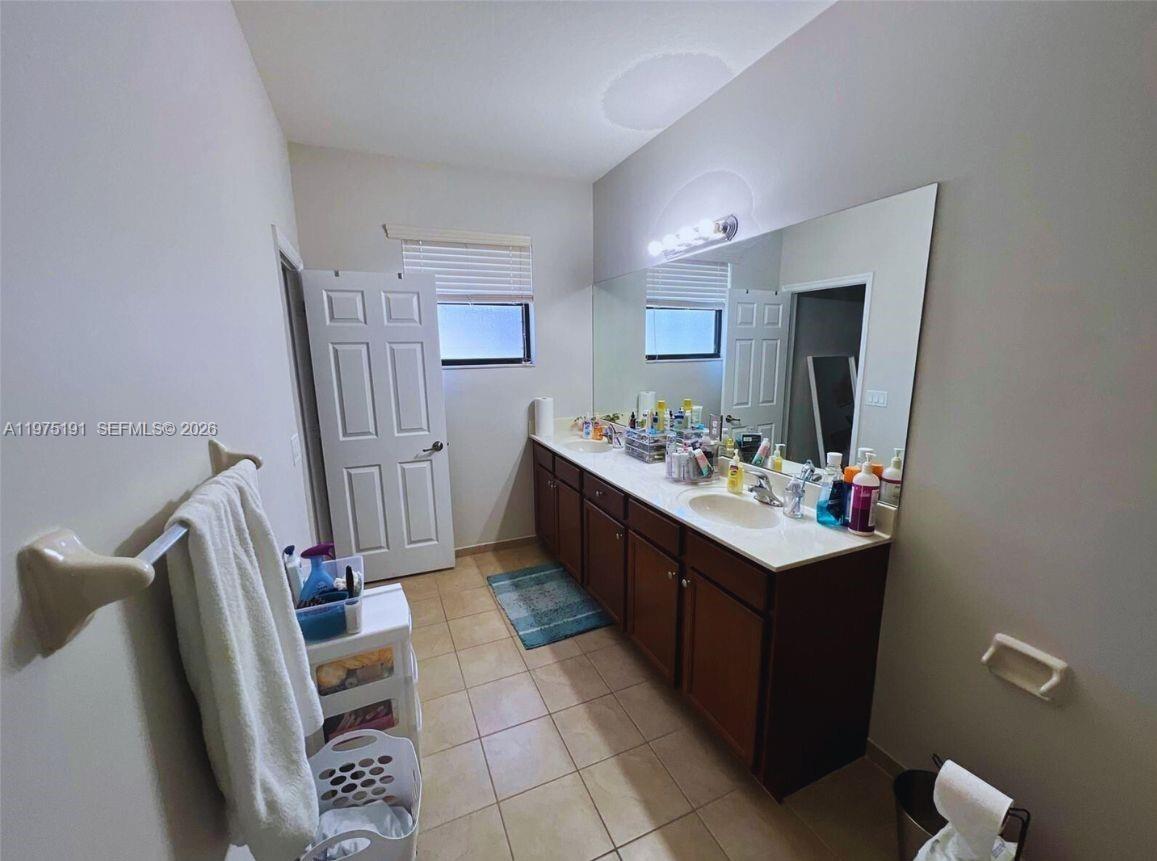 15076 Southwest 117th Terrace Miami, FL 33196 - Photo 23 of 31 a bathroom with a sink a mirror and a toilet