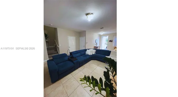 a living room with a couch and a potted plant
