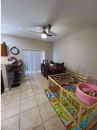 a kitchen with stainless steel appliances granite countertop a stove top oven a sink a dining table and chairs with wooden floor