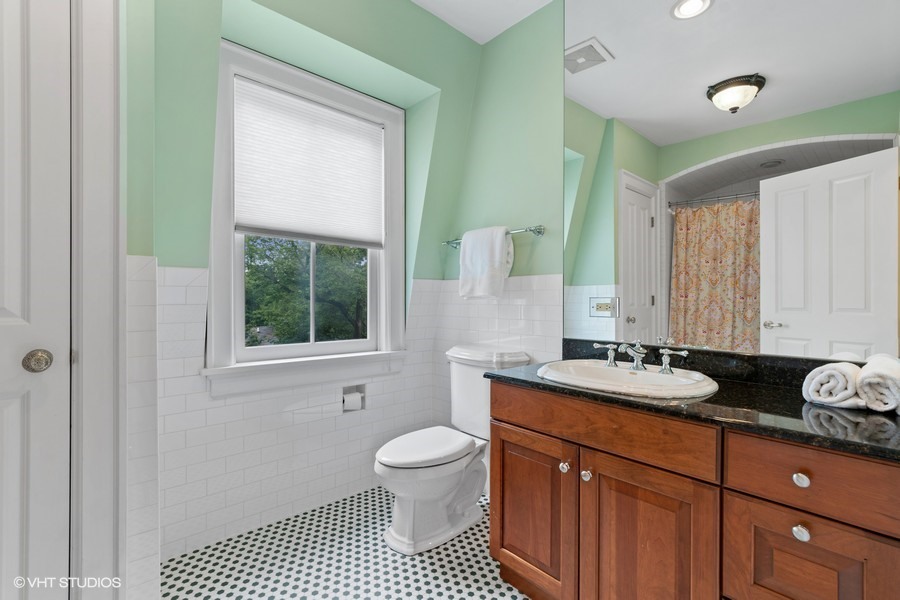 750 Glencoe Drive Glencoe, IL 60022 - Photo 17 of 26 a bathroom with a granite countertop toilet a sink and a window