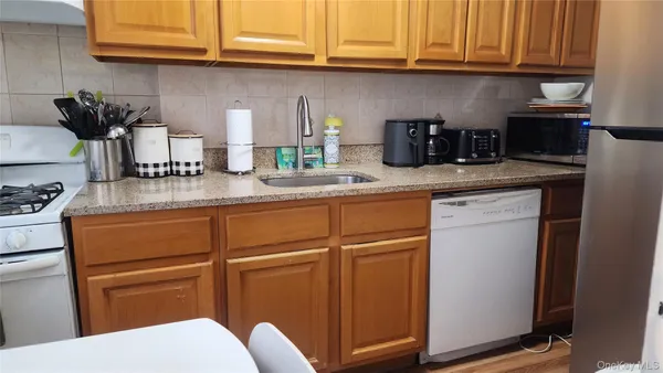 a kitchen with stainless steel appliances granite countertop a sink cabinets and a refrigerator