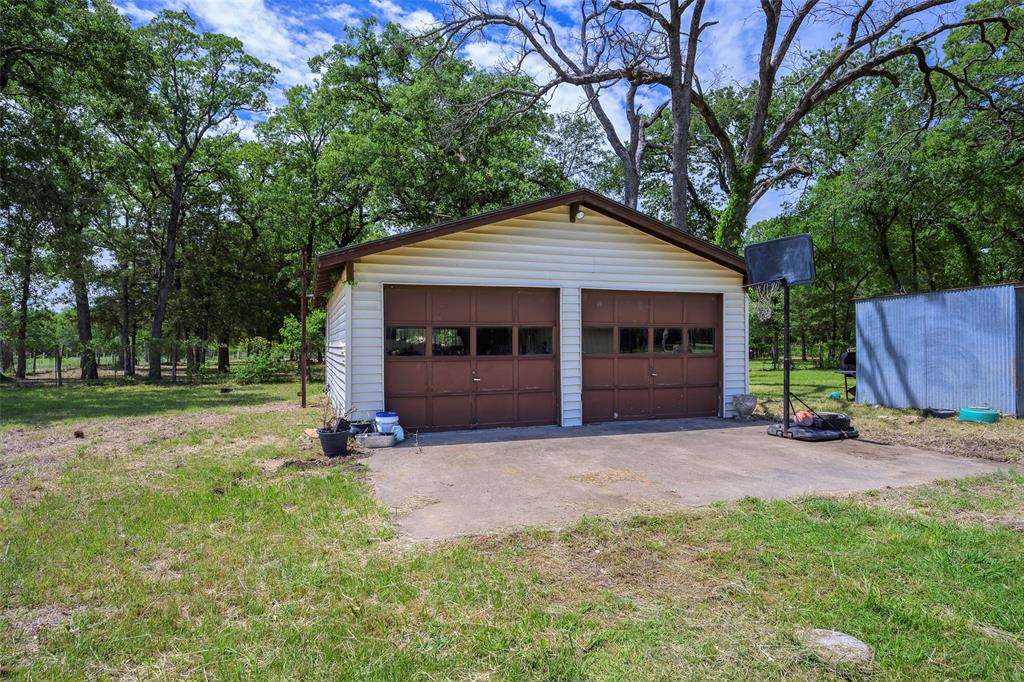 1113 West Will White Road Kemp, TX 75143 - Photo 19 of 22 a front view of a house with a garden and trees