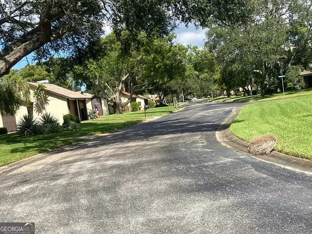 a view of a street with a house in the background