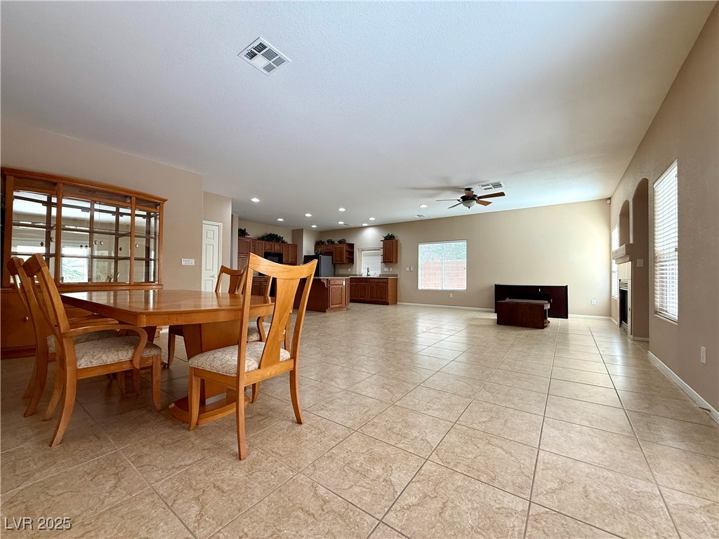 6031 Lamotte Avenue Las Vegas, NV 89141 - Photo 11 of 28 Dining room featuring recessed lighting, a fireplace, ceiling fan, and light tile patterned floors
