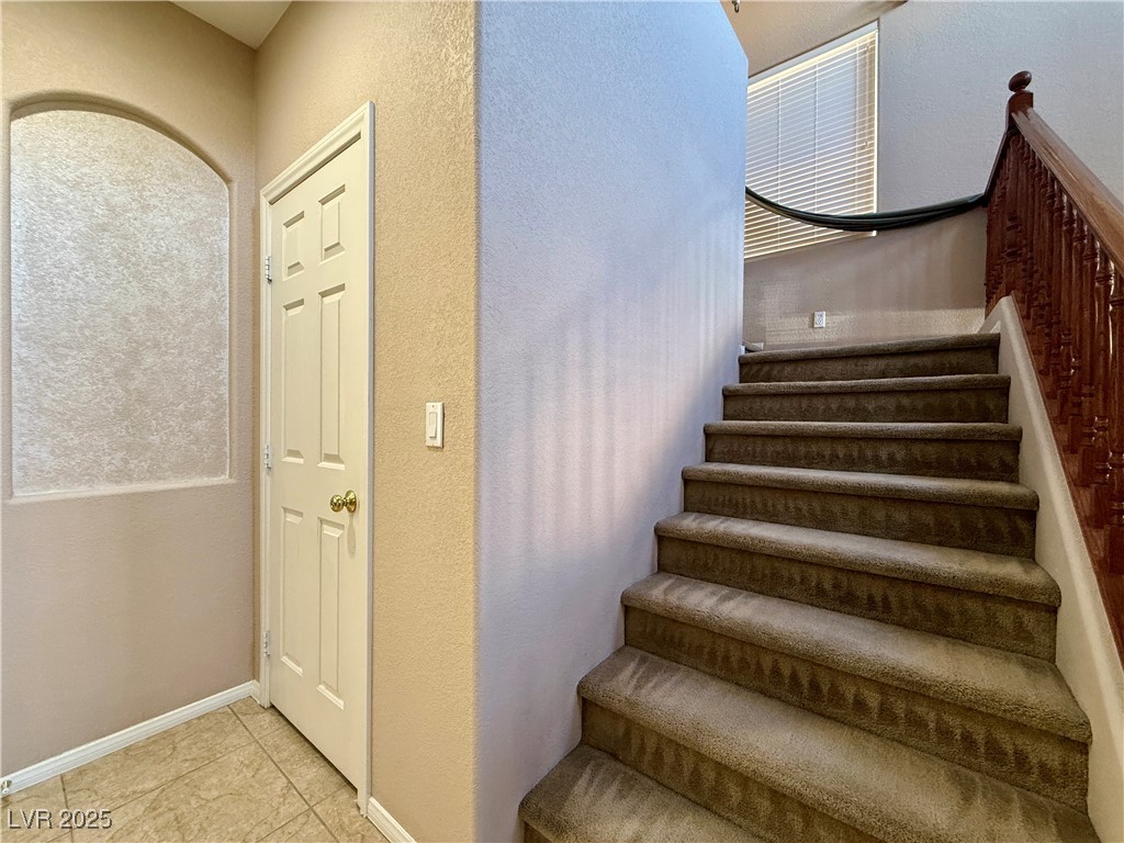 6031 Lamotte Avenue Las Vegas, NV 89141 - Photo 13 of 28 Stairs with a textured wall and tile patterned floors