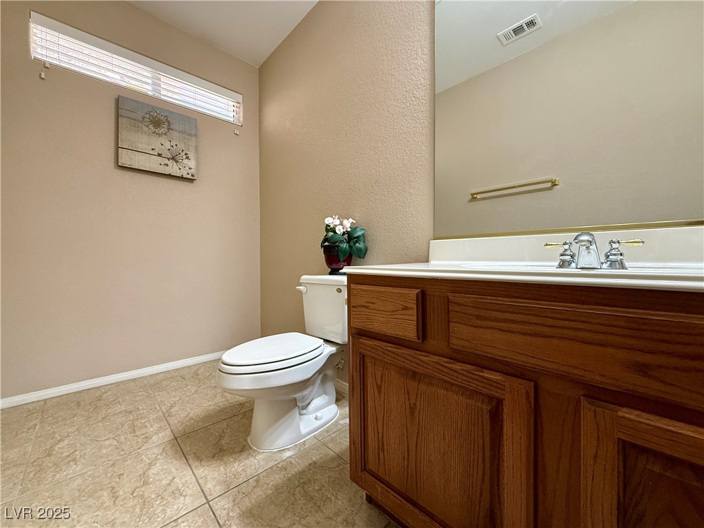 6031 Lamotte Avenue Las Vegas, NV 89141 - Photo 18 of 28 Bathroom featuring vanity, light tile patterned flooring, and a textured wall
