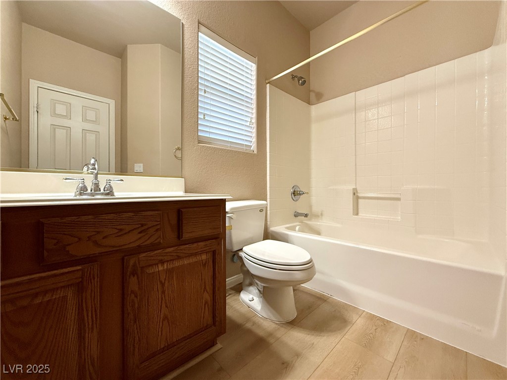 6031 Lamotte Avenue Las Vegas, NV 89141 - Photo 19 of 28 Bathroom with a textured wall, vanity, light wood-style flooring, and shower / bath combination