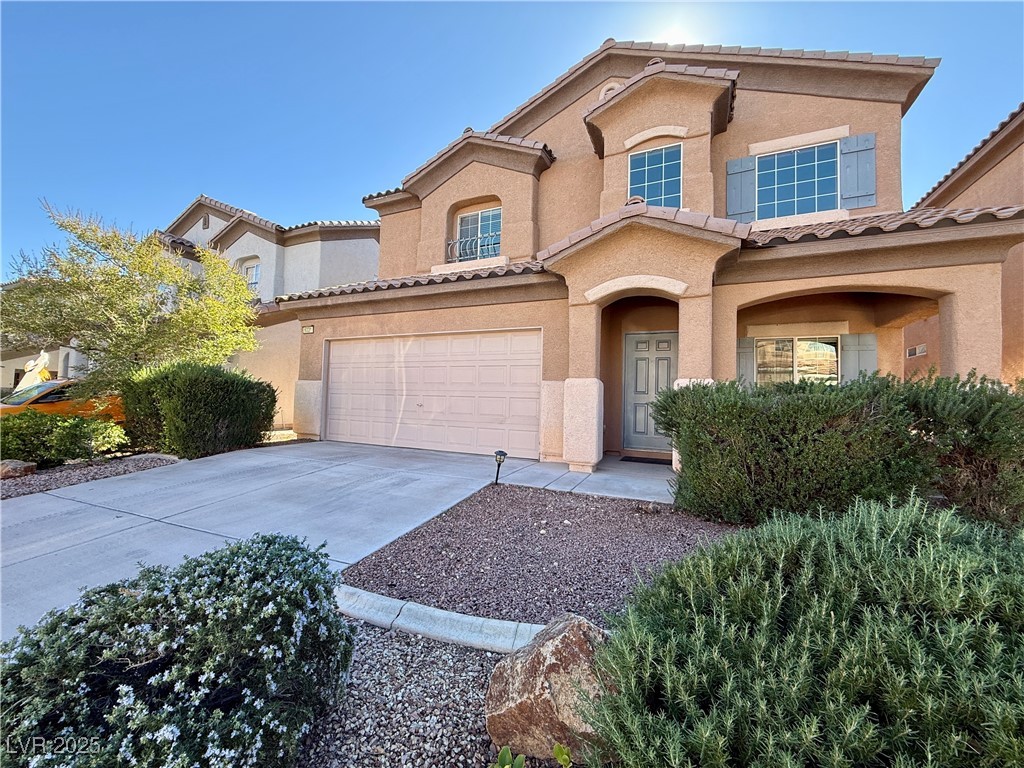 6031 Lamotte Avenue Las Vegas, NV 89141 - Photo 2 of 28 Mediterranean / spanish house with concrete driveway, stucco siding, a tiled roof, and a garage