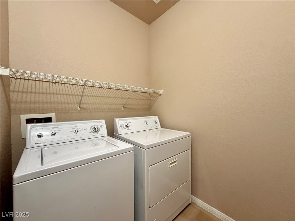 6031 Lamotte Avenue Las Vegas, NV 89141 - Photo 24 of 28 Laundry room with washer and clothes dryer and a textured wall