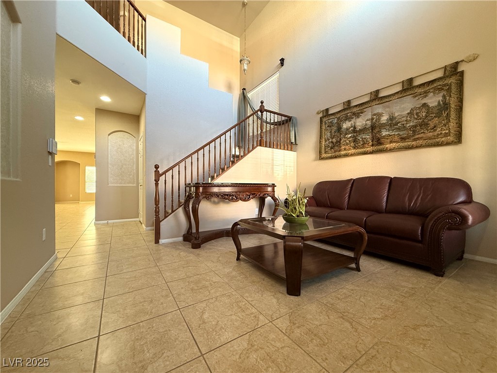 6031 Lamotte Avenue Las Vegas, NV 89141 - Photo 5 of 28 Living area with a high ceiling, stairs, arched walkways, and light tile patterned floors