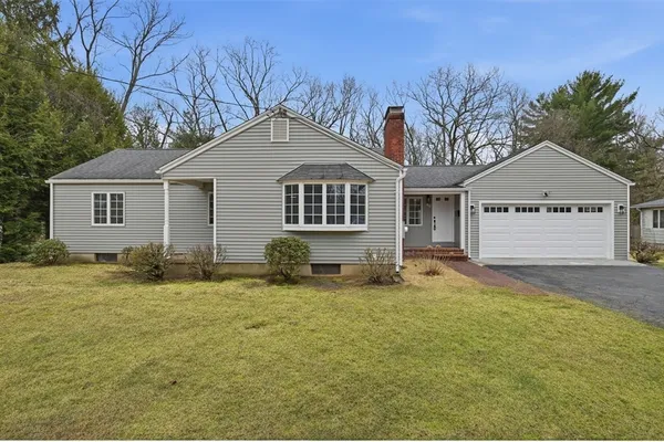 a house that has a large tree in front of it