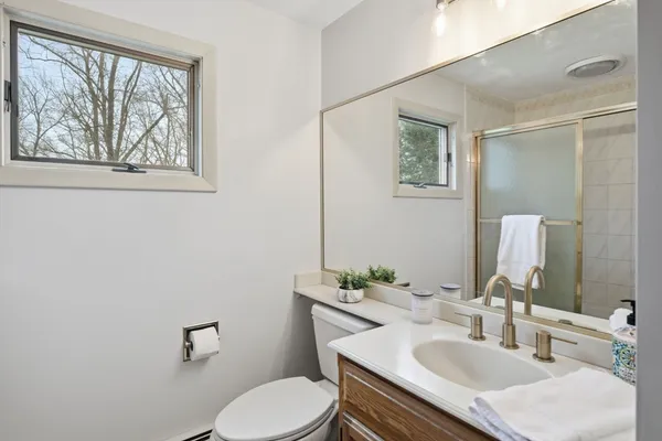 a bathroom with a sink vanity mirror and toilet
