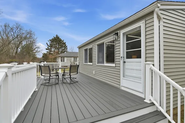 a roof deck with table and chairs and wooden floor