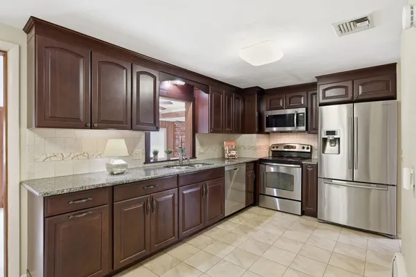 a kitchen with granite countertop stainless steel appliances a refrigerator sink and microwave