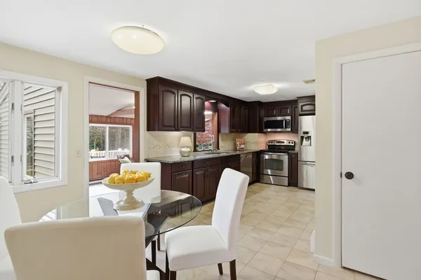 a living room with stainless steel appliances furniture and a kitchen view