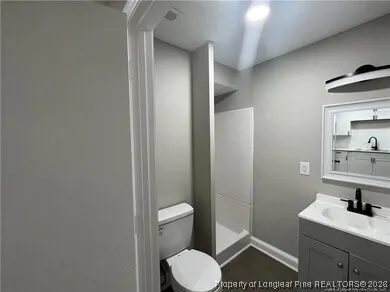 a bathroom with a toilet a sink and mirror