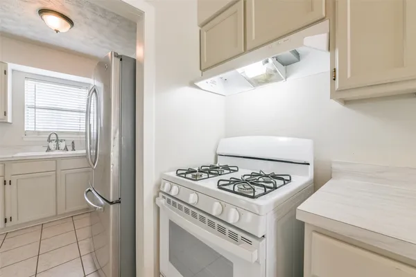 a white stove top oven sitting inside of a kitchen