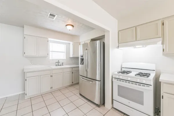 a kitchen with white cabinets and white appliances