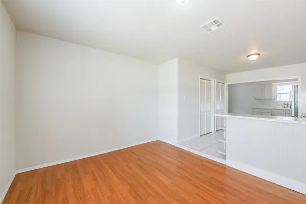 a view of empty room with wooden floor