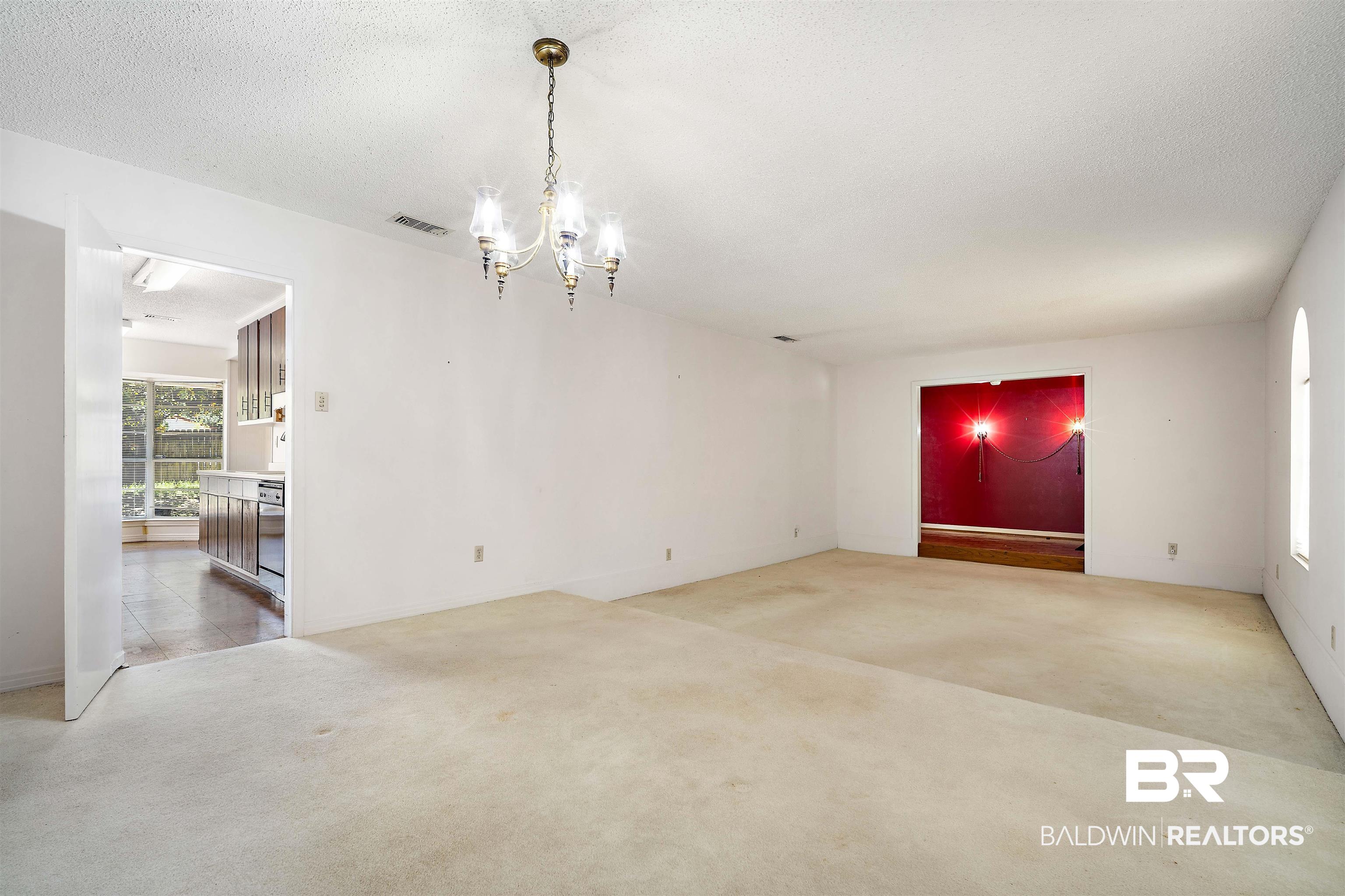 5559 Woodside Drive North Mobile, AL 36608 - Photo 16 of 28 Unfurnished dining area with light colored carpet, a chandelier, and a textured ceiling