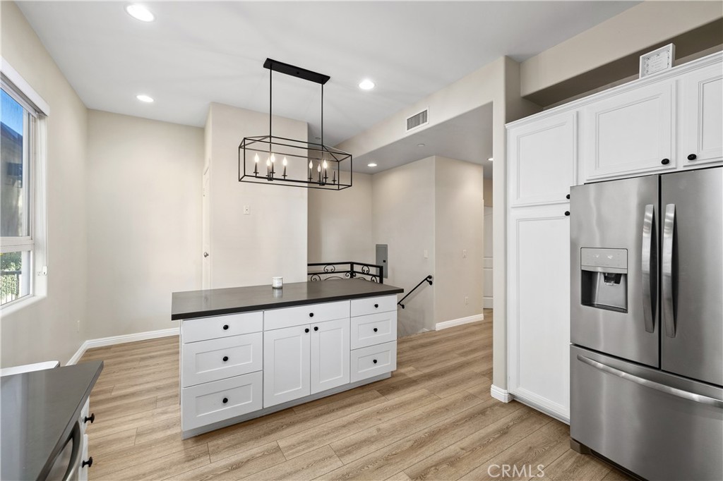 14535 Margate Street, Unit 13 Sherman Oaks, CA 91411 - Photo 5 of 22 a kitchen with granite countertop a refrigerator and a stove top oven