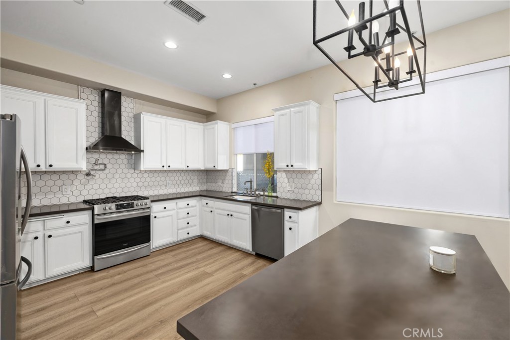 14535 Margate Street, Unit 13 Sherman Oaks, CA 91411 - Photo 6 of 22 a kitchen with granite countertop a stove a sink and a refrigerator
