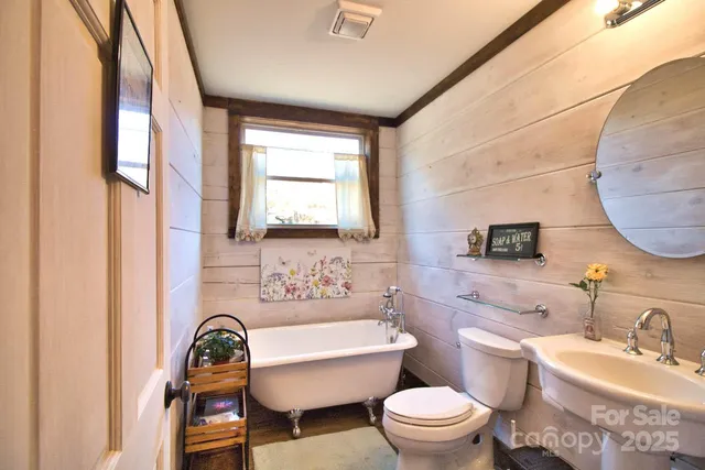 a bathroom with a sink toilet a mirror and tub