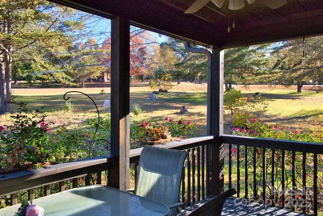 a view of a porch with a table and chairs and floor to ceiling window