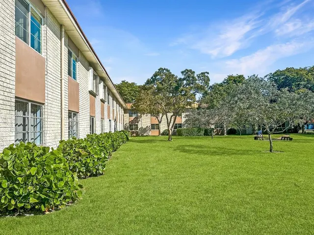 an aerial view of residential houses with outdoor space and parking