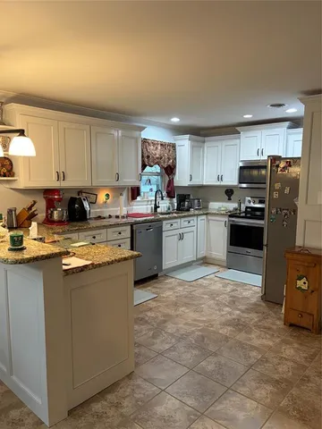 a kitchen with stainless steel appliances granite countertop a stove top oven a refrigerator a sink and dishwasher