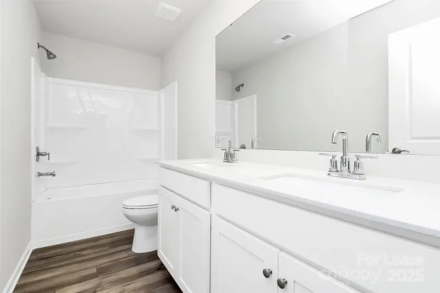 a bathroom with a double vanity sink toilet and shower