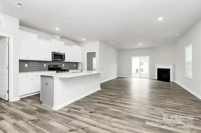 a view of kitchen with microwave stove refrigerator and cabinets