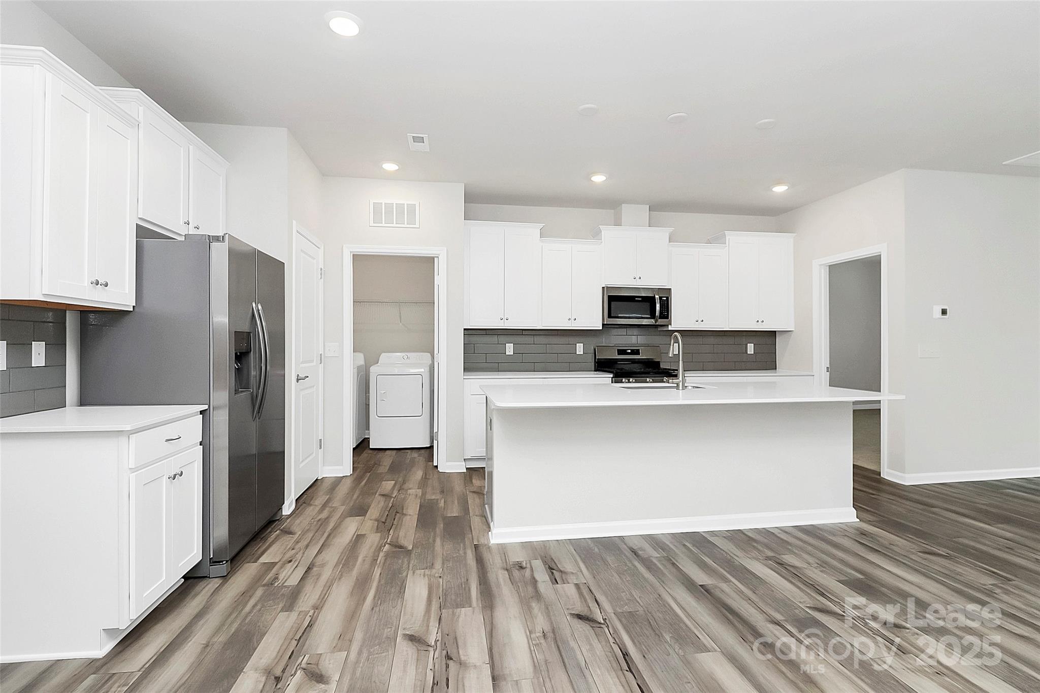1617 Swallow Tail Drive Belmont, NC 28012 - Photo 6 of 18 a view of kitchen with stainless steel appliances granite countertop a stove top oven a refrigerator and white cabinets with wooden floors