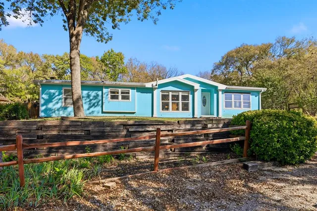 a kitchen with white cabinets stainless steel appliances a sink and a window