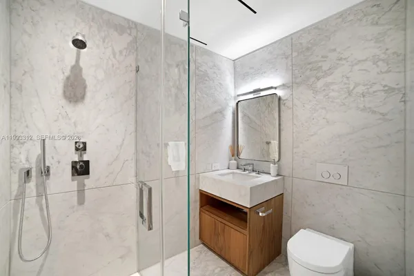 a bathroom with a granite countertop sink toilet and shower