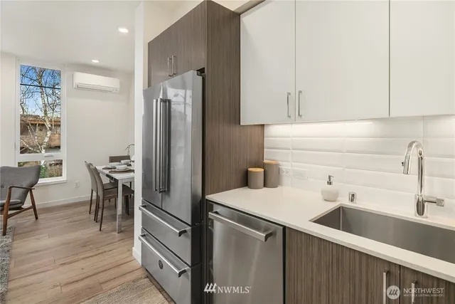a kitchen with a sink a refrigerator and chairs