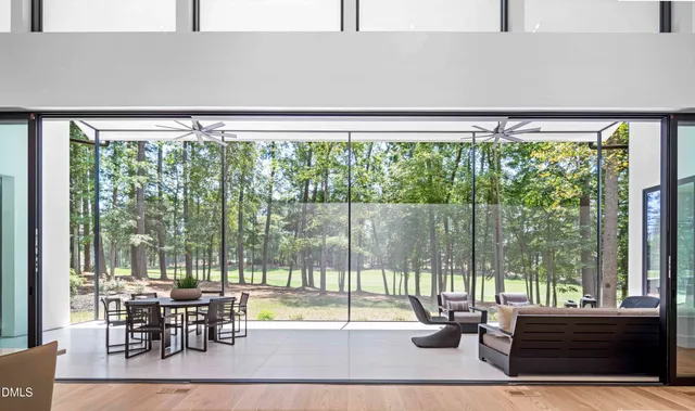 a living room with furniture a large window and a chandelier