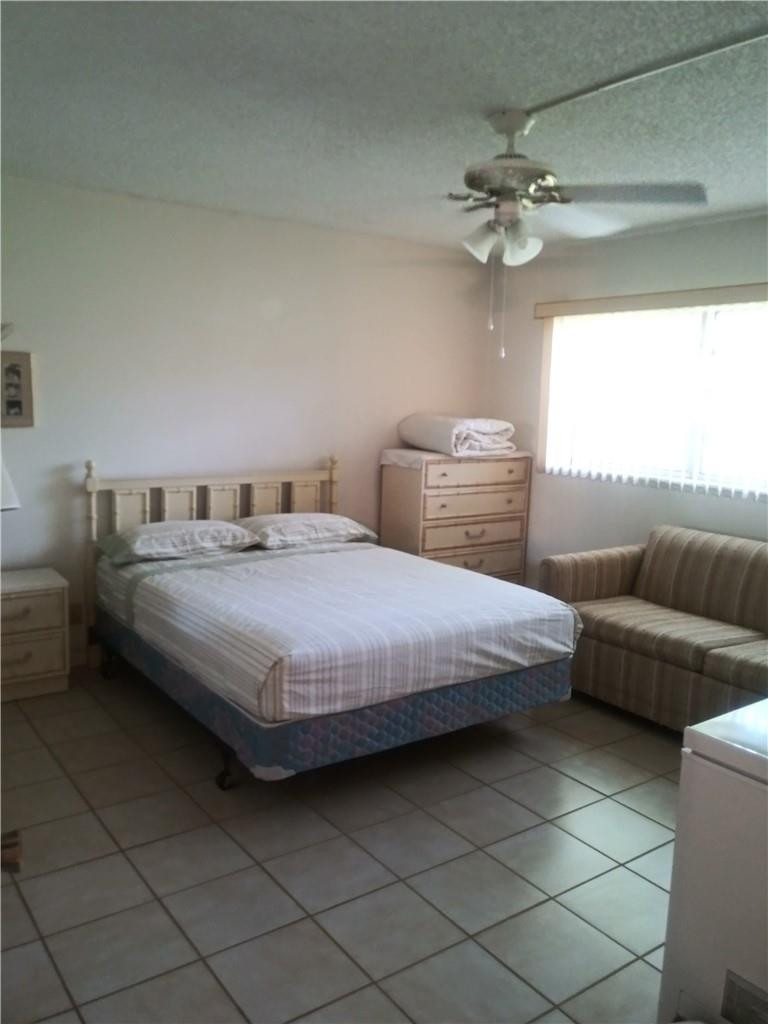 601 South State Road 7, Unit 1C Margate, FL 33068 - Photo 6 of 7 a bedroom with a bed and a chandelier