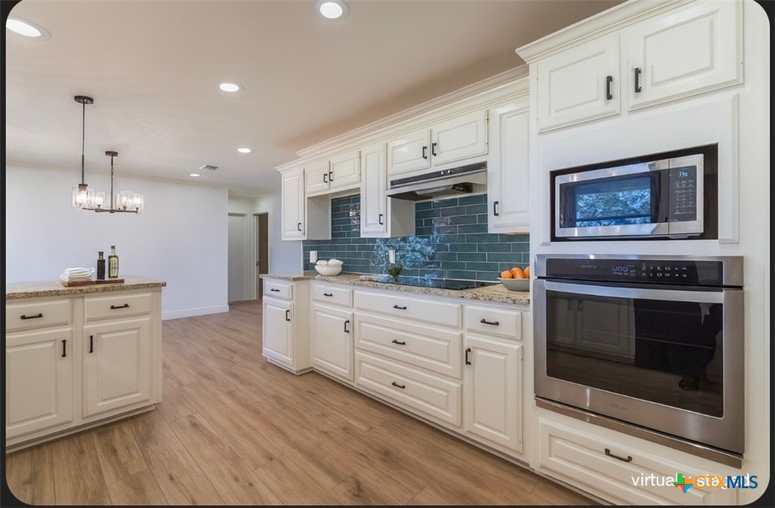 286 South Baese Road Elm Mott, TX 76640 - Photo 7 of 23 a kitchen with stainless steel appliances white cabinets and a fireplace
