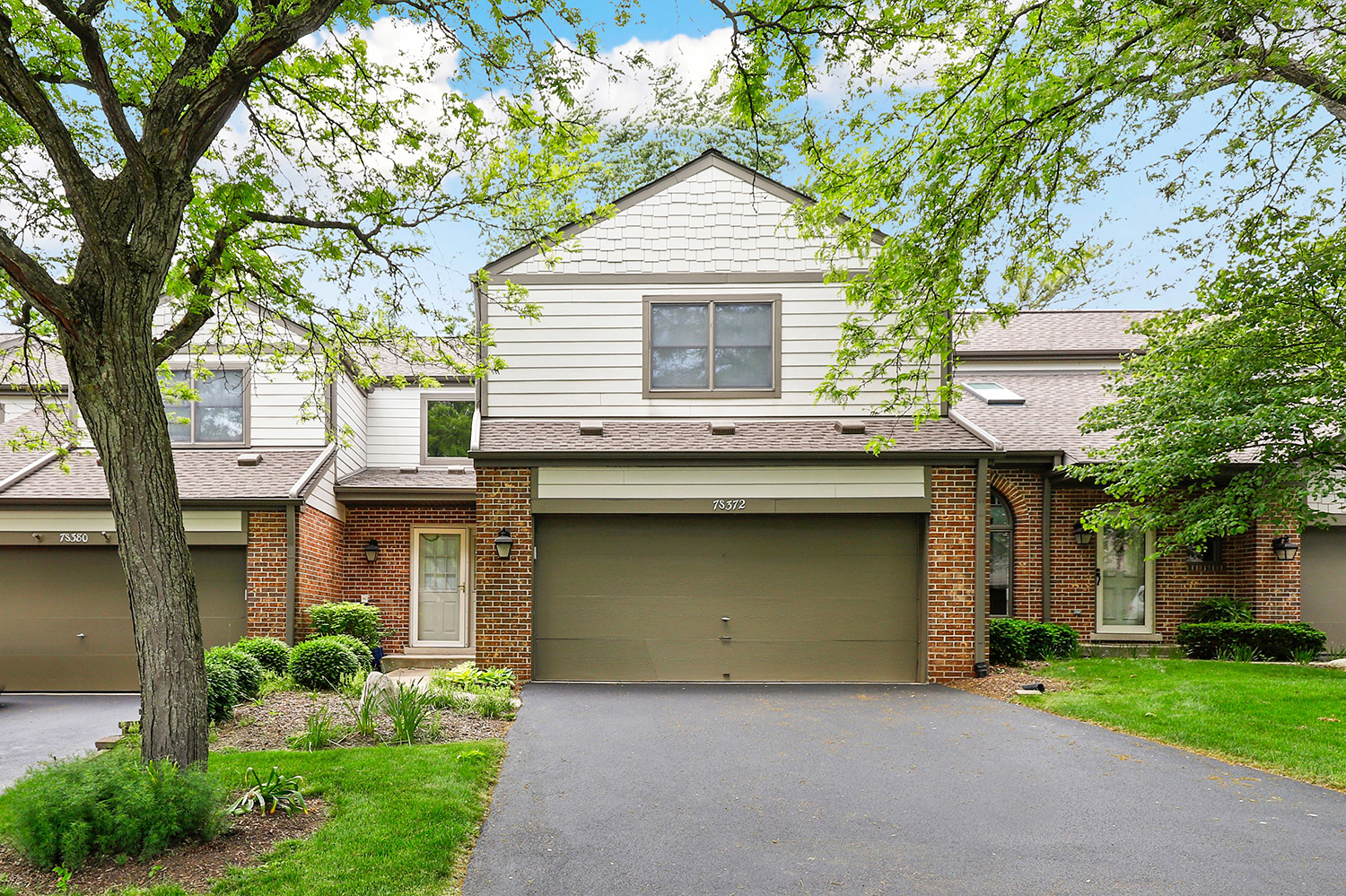 a front view of a house with a garden and garage