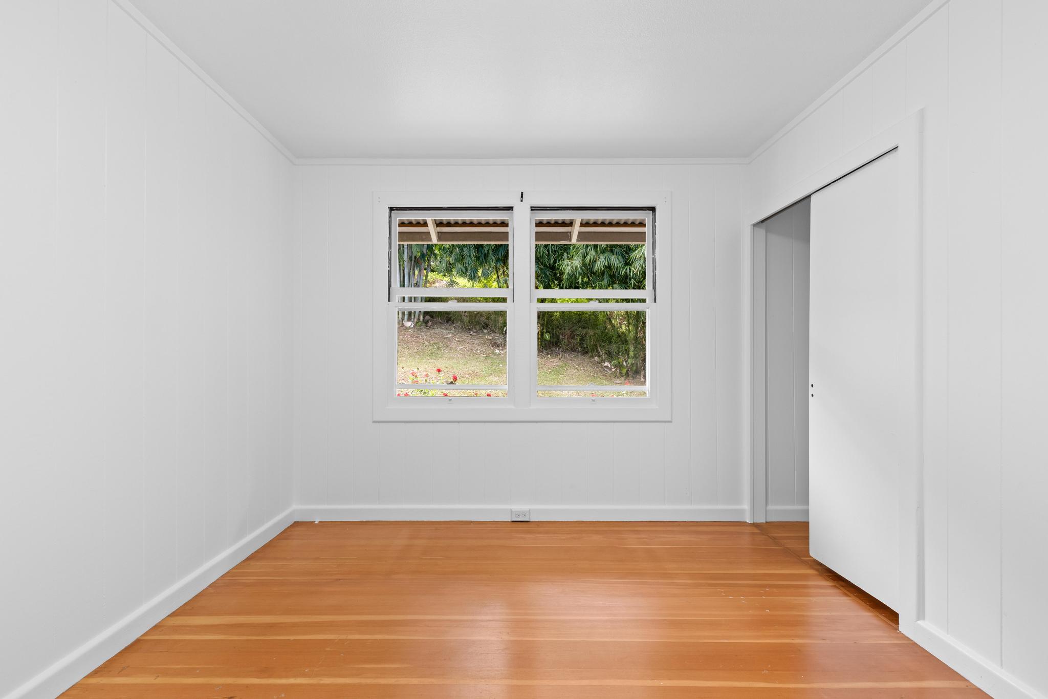 53 Ekaha Street Hilo, HI 96720 - Photo 19 of 29 a view of an empty room with wooden floor and windows