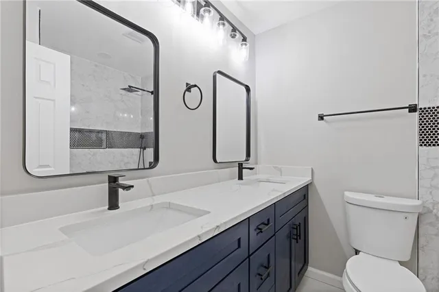 a bathroom with a sink a toilet and mirror