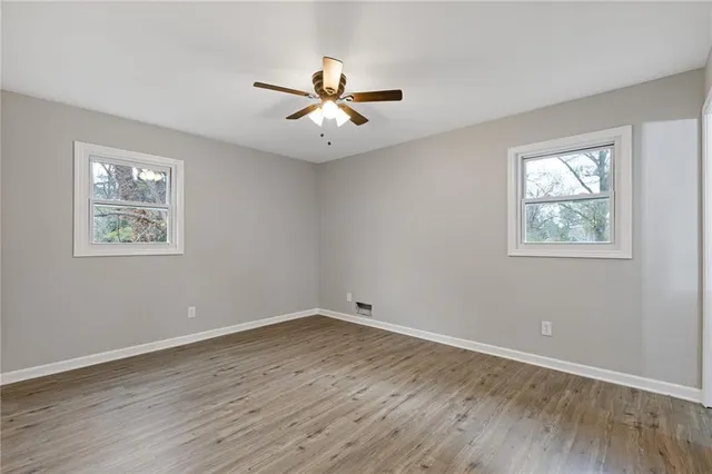 a view of empty room with wooden floor