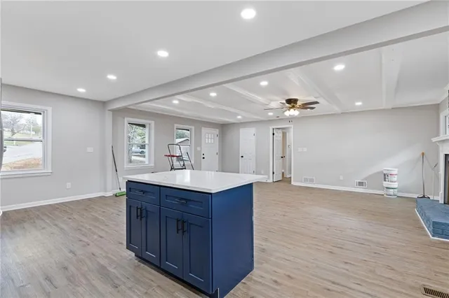a view of a kitchen island a sink wooden floor and a living room