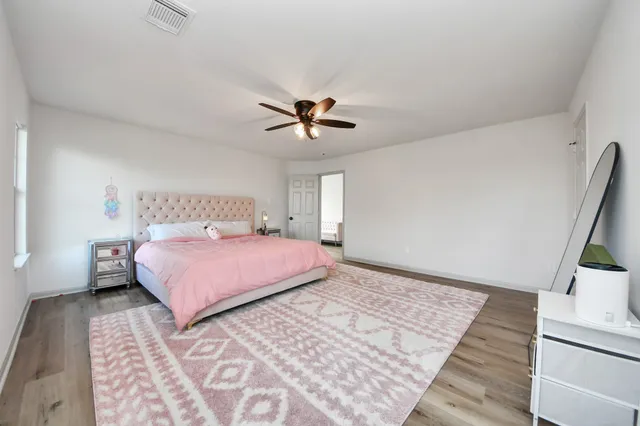 a bedroom with a bed rug and wooden floor